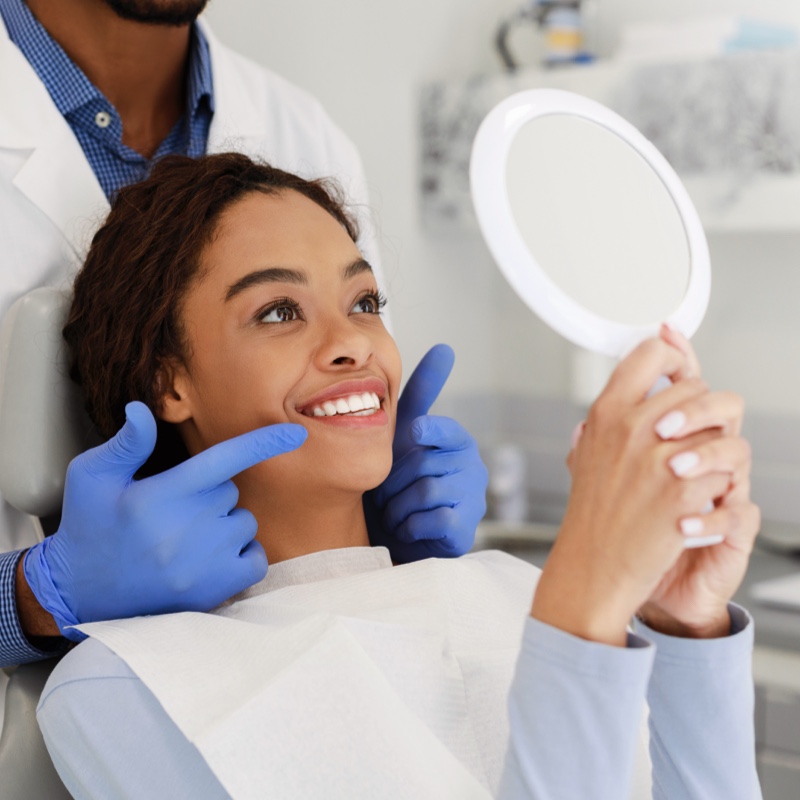 woman holding mirror and smiling